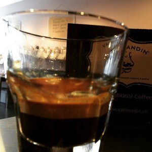 A glass cup of espresso freshly prepared with Valmandin artisan roasted coffee.