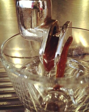 Valmandin Porta Azul crema coming out of the portafilter's spout - so thick it seems to be suspended in space.